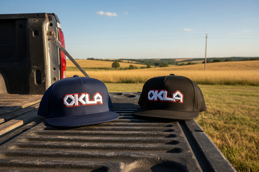 Two caps with 'OKLA' logo on a white background
