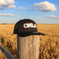 Black cap with 'OKLA' logo on a white surface