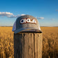 Gray cap with 'OKLA' logo on a light gray background