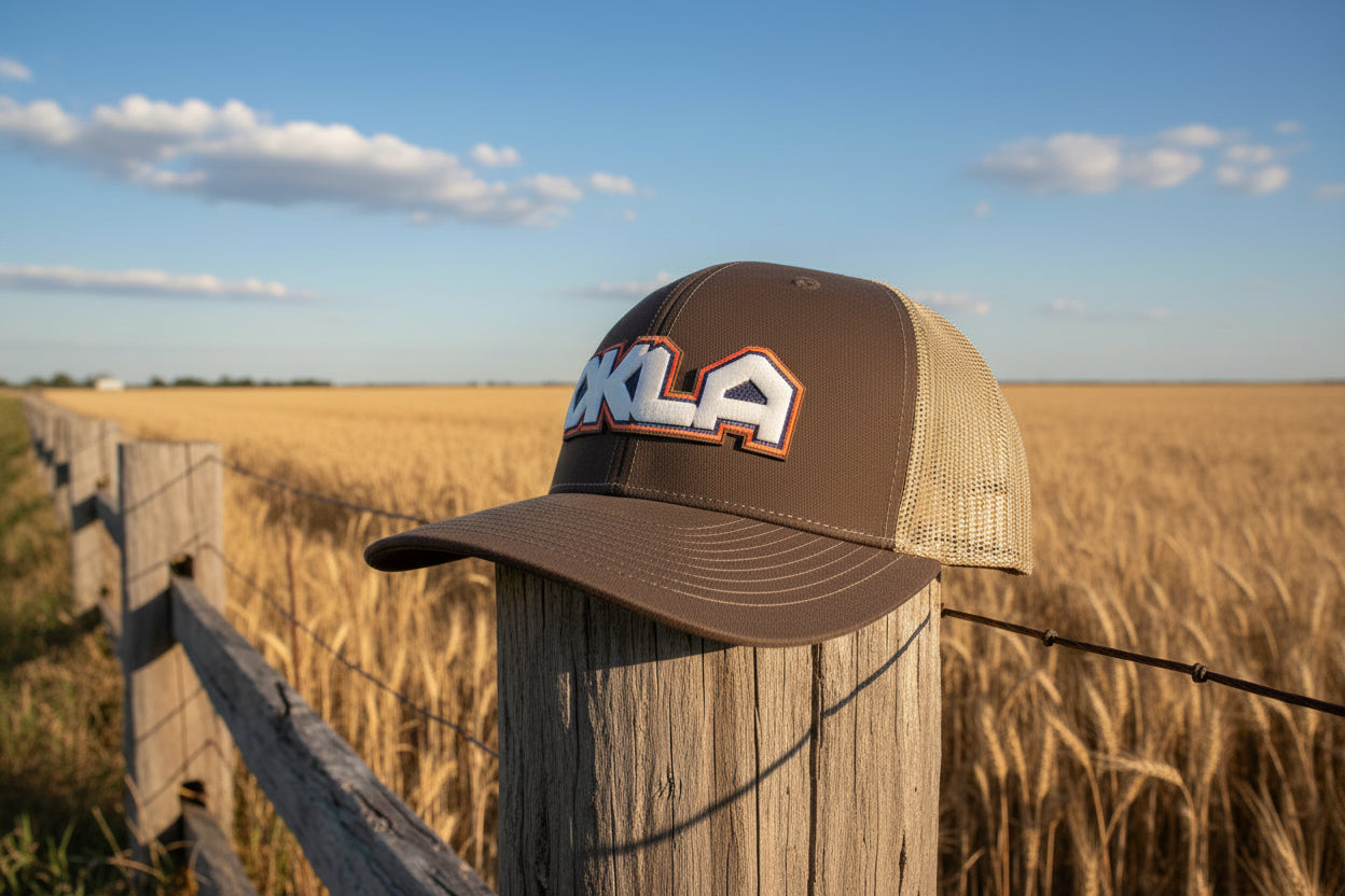 Brown trucker cap with 'OKLA' logo on a gray background