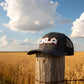Black cap with 'OKLA' branding on a white surface