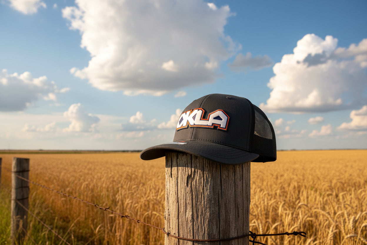 Black cap with 'OKLA' branding on a white surface